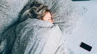 Kobieta śpi w łóżku