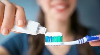 Biała pasta do zębów wyciskana z tubki na szczoteczkę