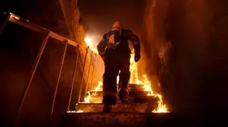 Strażak na schodach płonącego domu