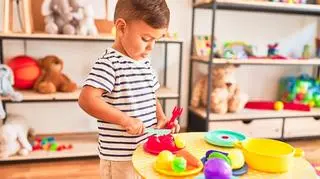 dziecko bawi się plastikowymi naczyniami