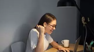 kobieta cieszy się patrząc w laptop