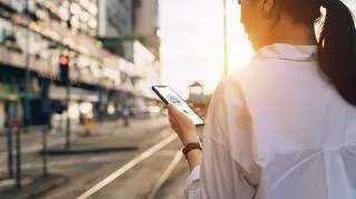 Kobieta, która trzyma w dłoni telefon komórkowy 