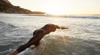 Pływak w piankowym stroju skaczący do morza