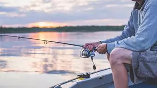 Mężczyzna łowi ryby na łódce