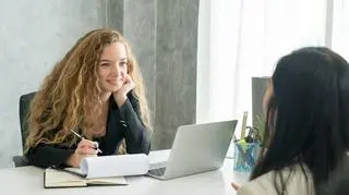 Dwie kobiety rozmawiają o pracy, analizują CV i list motywacyjny. 