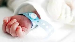 Rączka niemowlaka z opaską szpitalną owiniętą wokół nadgarstka 
