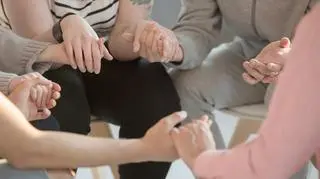 Terapia grupowa. Ludzie trzymają się za ręce 