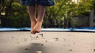 stopy dziecka skaczące na trampolinie