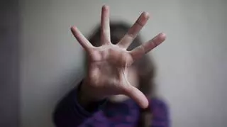 dziewczynka zasłania się ręką krzyczy wystraszona pedofilia
