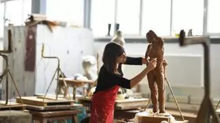kobieta rzezbi z gliny w pracowni