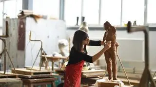 kobieta rzezbi z gliny w pracowni