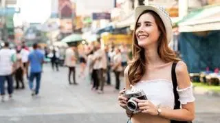 Turystka z aparatem fotograficznym na zatłoczonej ulicy