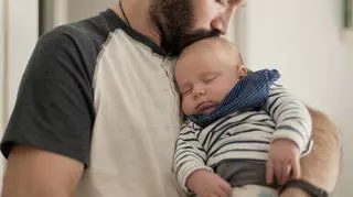 Młody ijciec całuje swoje dziecko