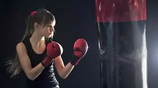 Młoda kobieta ćwiczy z bokserskim workiem treningowym