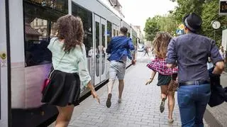 Pasażerowie biegną do tramwaju w Krakowie 