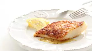 Filet rybny na białym talerzu z cytryną