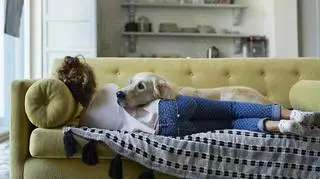 Kobieta z psem na kanapie w salonie