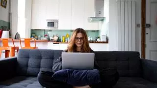 kobieta, która trzyma laptopa na kolanach 