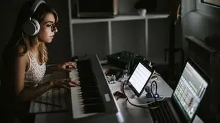 Młoda kobieta gra na organach w domowym studio