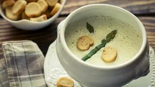 Zupa szparagowa w białej misce z grzankami