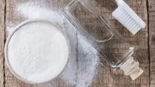 soda oczyszczona ocet w butelce szczoteczka do zebow na stole drewnianym ujecie z gory