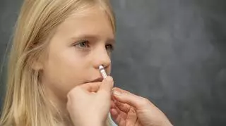 Dziewczynka, która ma podawaną szczepionkę do nosa 