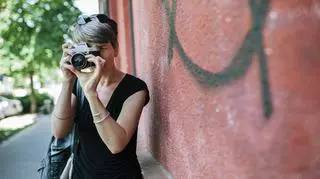 Kobieta robi zdjęcia aparatem analogowym