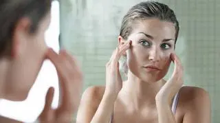 Kobieta smaruje sobie twarz kremem