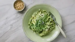 Makaron z zielonym pesto na talerzy z widelcem