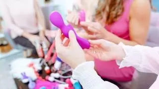 Kobiece dłonie trzymające fioletową zabawkę erotyczną