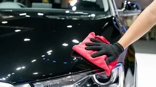 Mężczyzna pucuje czarne auto