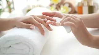 Kobiece dłonie podczas zabiegu stylizacji paznokci u kosmetyczki