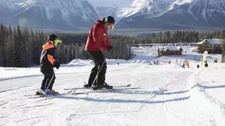 Mężczyzna dzieckiem jeżdżą na nartach