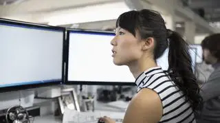 Kobieta pracuje na dwóch monitorach