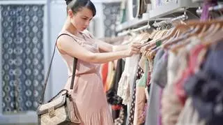 Kobieta w sklepie wybiera sukienkę 