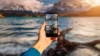 Mężczyzna robi zdjęcie telefonem krajobrazowi