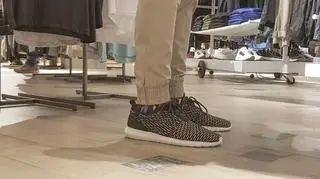 Mężczyzna w spodniach stoi w sklepie