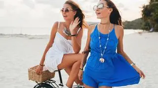 Dwie dziewczyny na plaży w letnich sukienkach 