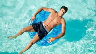 Młody mężczyzna w kąpielówkach na basenie