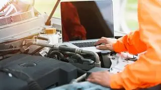 Mechanik sprawdzający z laptopem pojazd. 