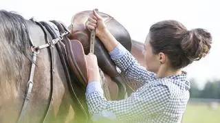 Kobieta siodła konia
