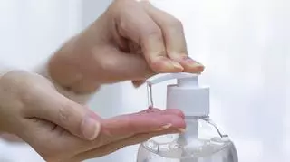Kobieta, która używa płynu do dezynfekcji rąk 