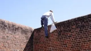 Mężczyzna przeskakujący przez mur