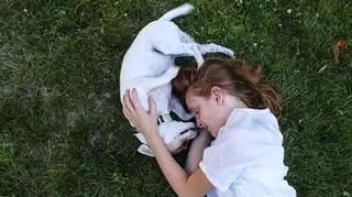 dziewczynka z psem na trawie