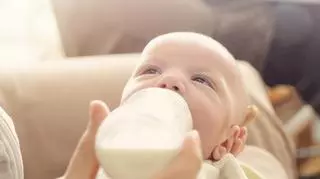 Matka karmi niemowlaka przez butelkę