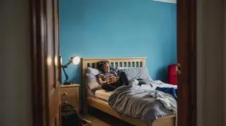 Nastolatek słucha muzyki leżąc na łóżku 