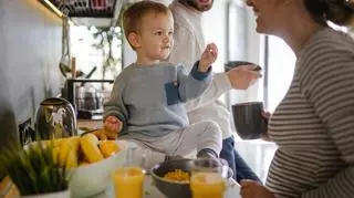 Małe dziecko je zdrowe śniadanie z rodzicami