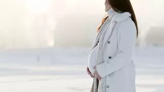 Kobieta w ciąży w białym płaszczu 
