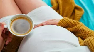 Kobieta w ciąży, która pije kawę 
