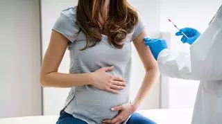 Kobieta w ciąży szczepi się przeciw COVID-19.